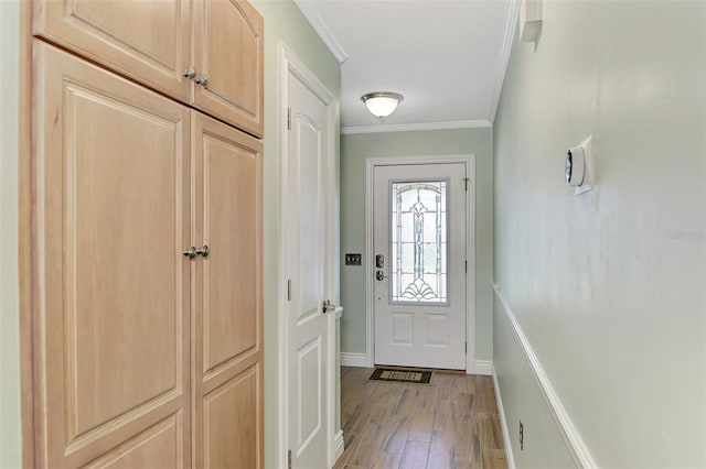 doorway with ornamental molding and light wood finished floors