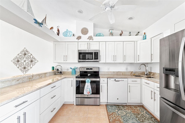 kitchen featuring lofted ceiling, sink, white cabinetry, appliances with stainless steel finishes, and light tile patterned floors