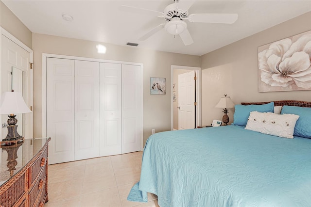 tiled bedroom with ceiling fan and a closet