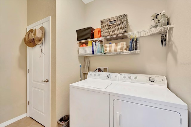 clothes washing area with light tile patterned flooring and washer and dryer