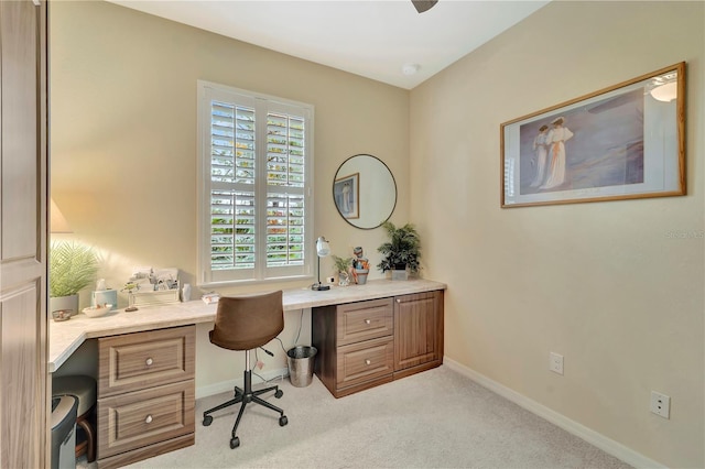 carpeted home office featuring built in desk