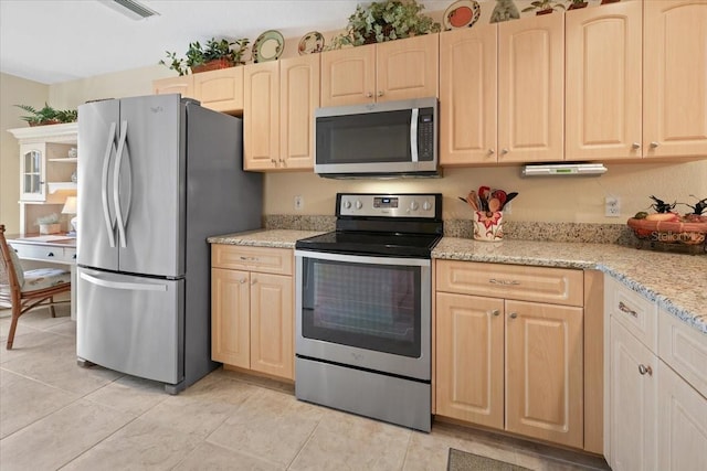 kitchen featuring light tile patterned floors, stainless steel appliances, light brown cabinets, and light stone counters