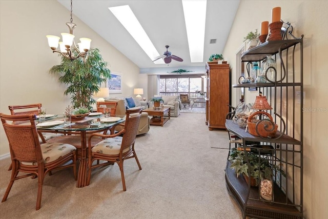 carpeted dining room with vaulted ceiling with skylight and ceiling fan with notable chandelier