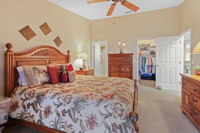 carpeted bedroom with ceiling fan, a closet, and a walk in closet