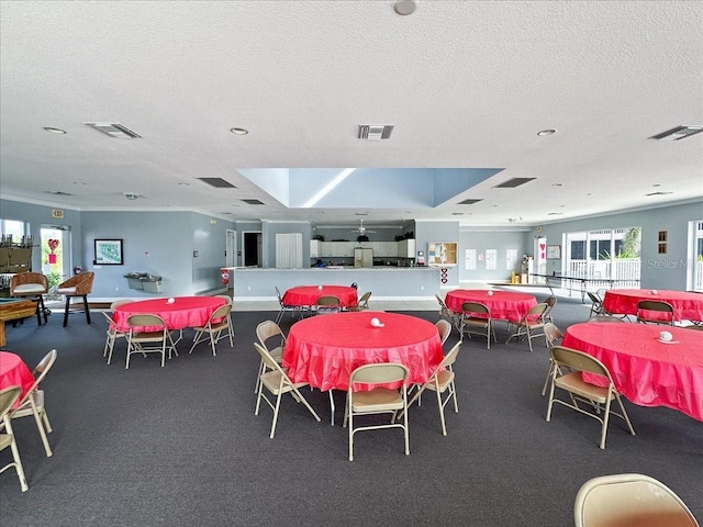 dining room with a textured ceiling and crown molding