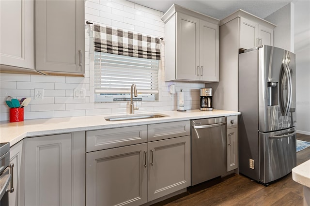 kitchen with gray cabinets, appliances with stainless steel finishes, sink, and dark hardwood / wood-style floors