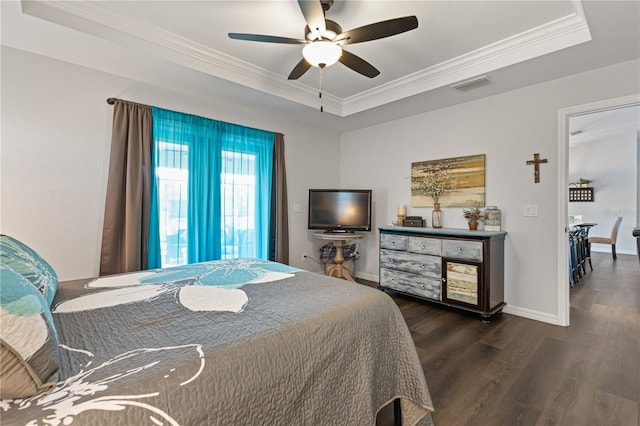 bedroom featuring crown molding, dark hardwood / wood-style floors, a raised ceiling, and ceiling fan