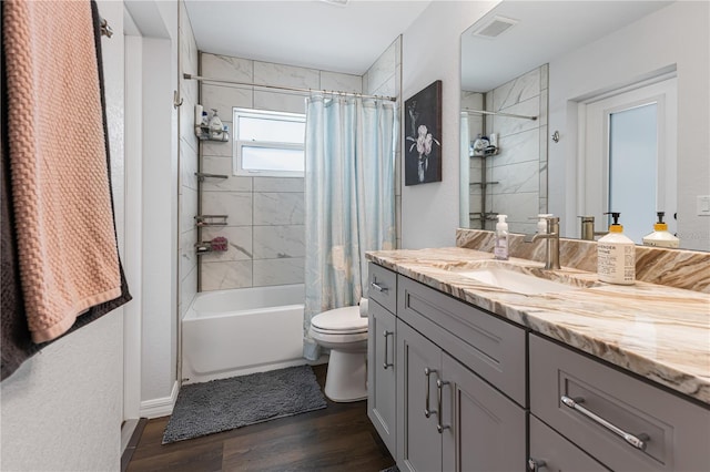 full bathroom featuring vanity, hardwood / wood-style flooring, toilet, and shower / bathtub combination with curtain