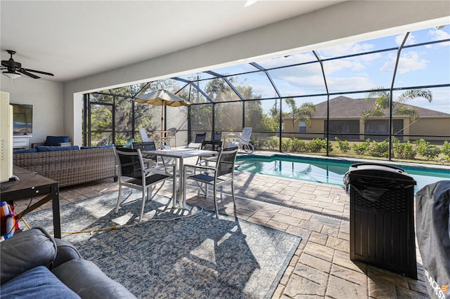 view of swimming pool featuring ceiling fan, an outdoor hangout area, glass enclosure, and a patio