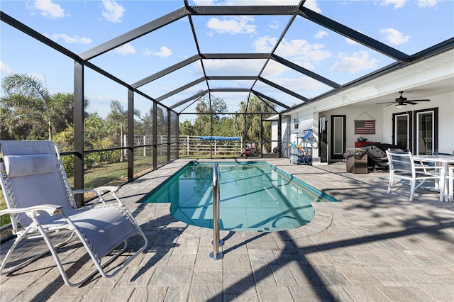 view of swimming pool featuring an outdoor living space, a lanai, a patio area, and ceiling fan