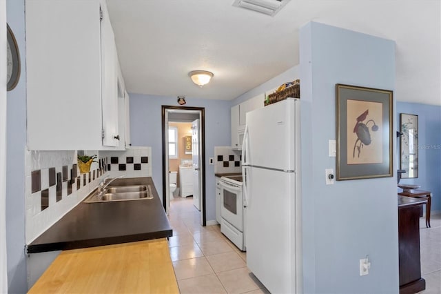 kitchen featuring white appliances, light tile patterned floors, sink, white cabinets, and tasteful backsplash