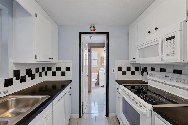 kitchen with white appliances, white cabinets, light tile patterned flooring, and tasteful backsplash