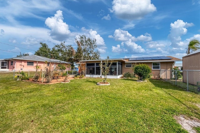 back of property featuring solar panels, a sunroom, and a yard