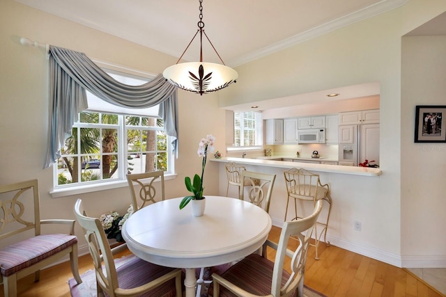 dining room featuring light hardwood / wood-style floors and ornamental molding