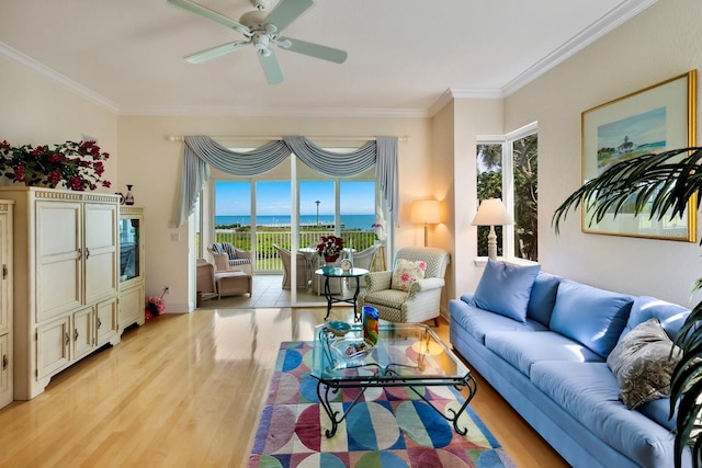 living room featuring ceiling fan, crown molding, a water view, and light wood-type flooring