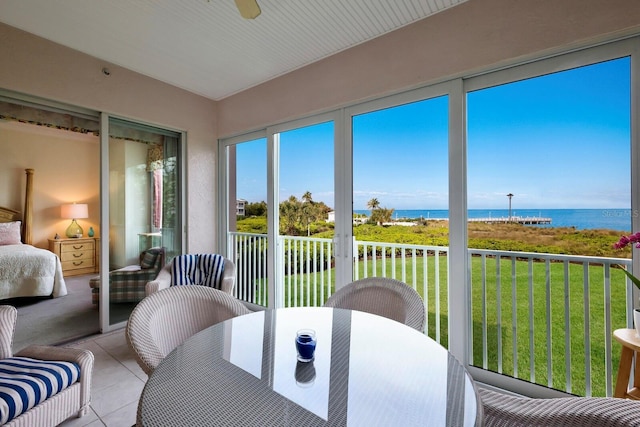 sunroom / solarium featuring a water view