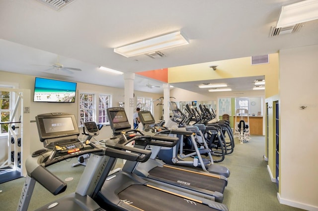 workout area featuring decorative columns, ceiling fan, and a healthy amount of sunlight