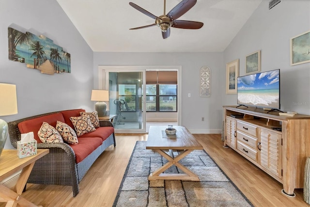 living room featuring ceiling fan, vaulted ceiling, and light wood-type flooring