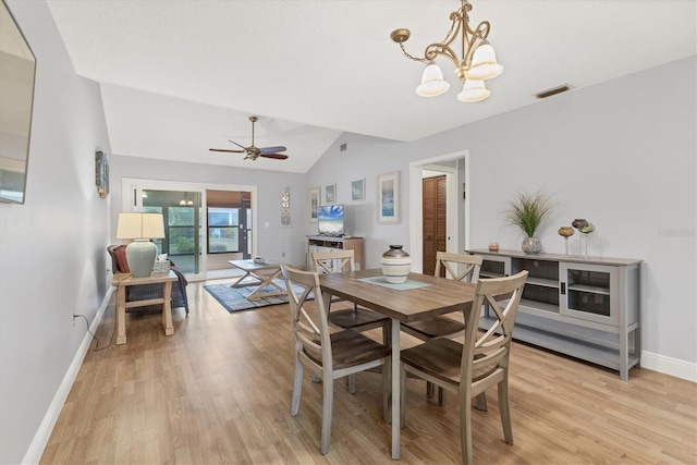 dining space featuring lofted ceiling, ceiling fan with notable chandelier, and light wood-type flooring