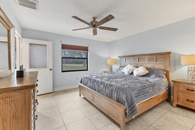 bedroom featuring light tile patterned floors, a textured ceiling, and ceiling fan