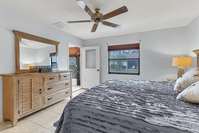 bedroom featuring light tile patterned flooring, ceiling fan, multiple windows, and a textured ceiling