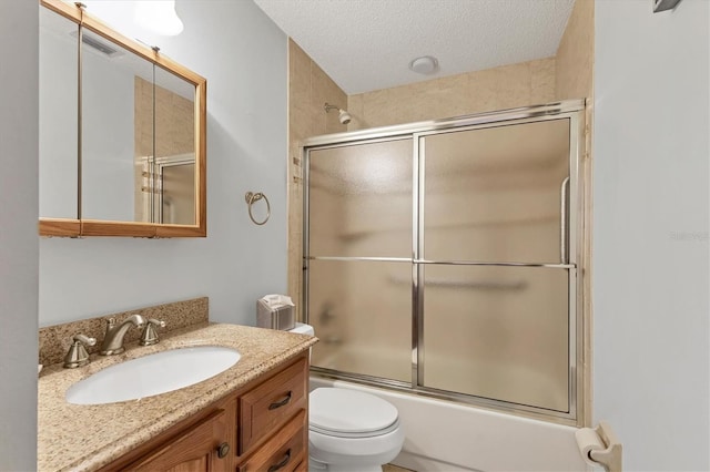 full bathroom with enclosed tub / shower combo, vanity, toilet, and a textured ceiling