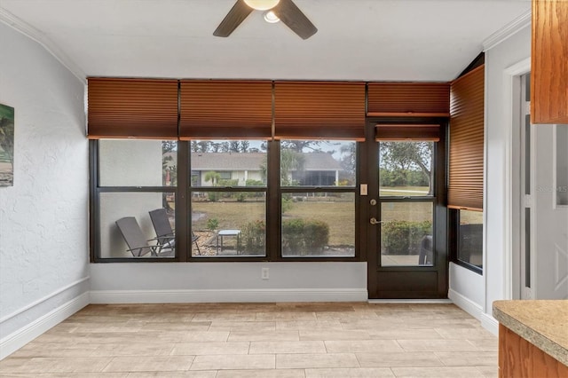 unfurnished sunroom with ceiling fan