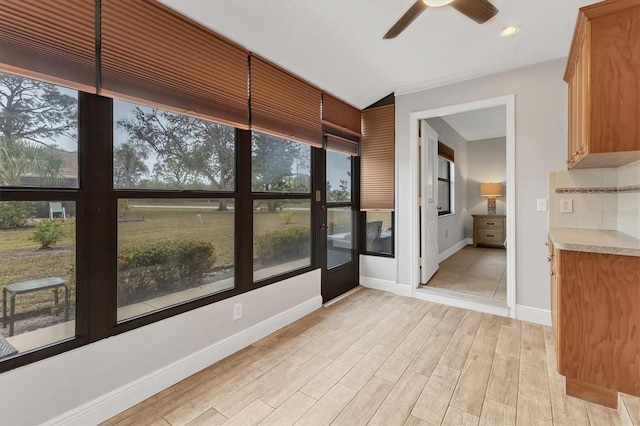 unfurnished sunroom featuring a healthy amount of sunlight and ceiling fan