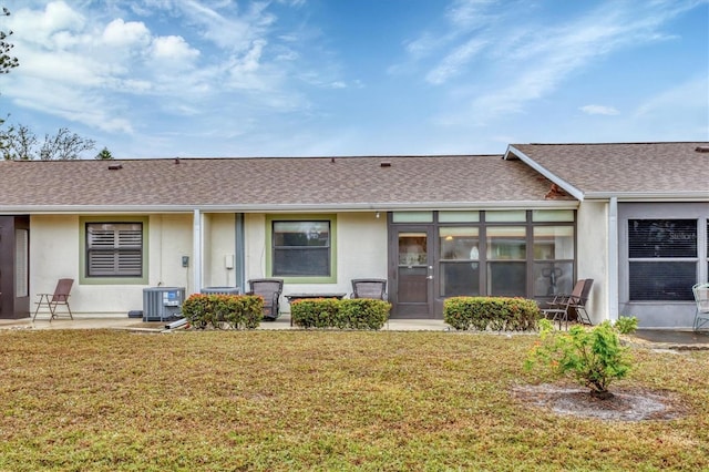 view of front of property featuring a front lawn and central air condition unit