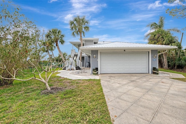 view of front of property with a garage, a front yard, and central AC