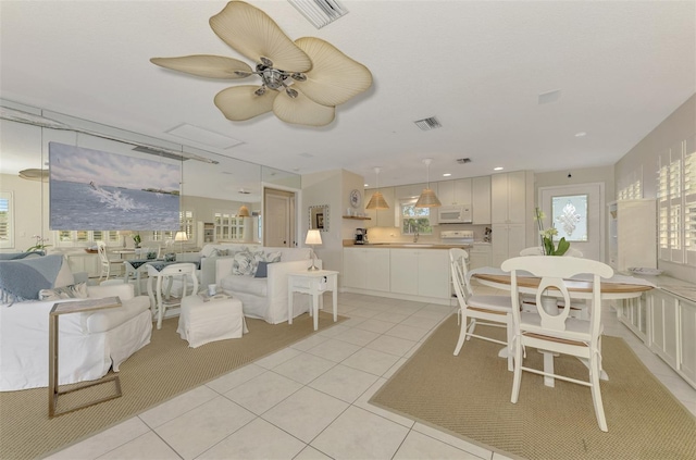 dining area with ceiling fan, light tile patterned floors, and a healthy amount of sunlight