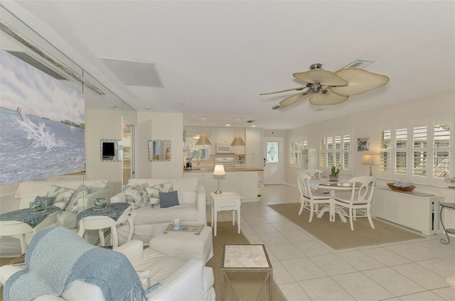 tiled living room with ceiling fan and sink