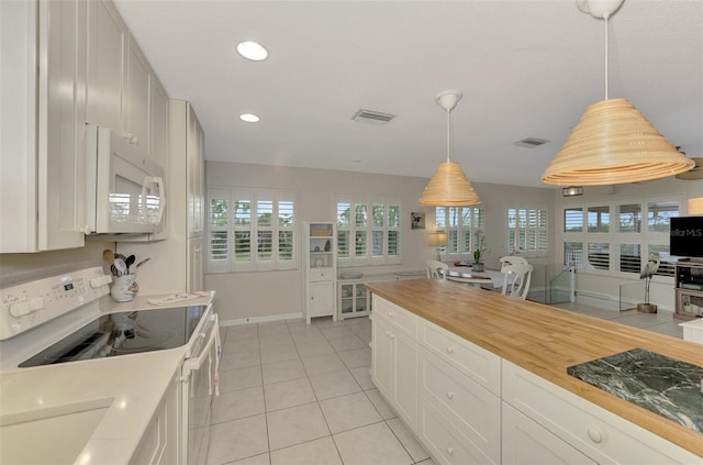 kitchen featuring white cabinetry, wooden counters, white appliances, light tile patterned flooring, and hanging light fixtures