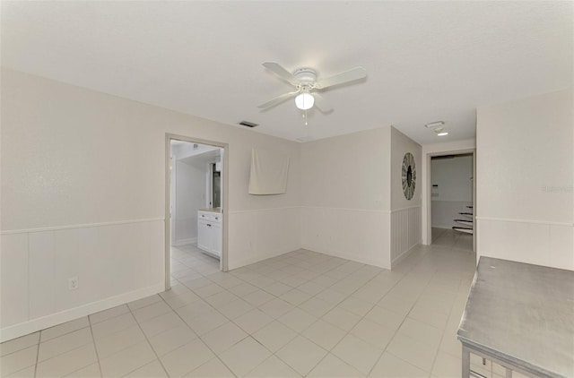 spare room with ceiling fan, a textured ceiling, and light tile patterned floors