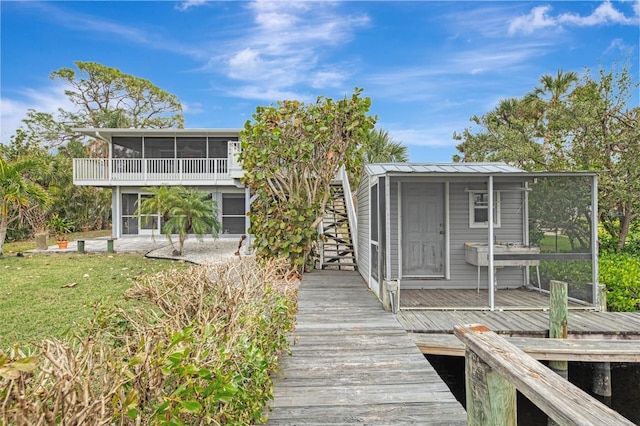 back of property with a patio area and a sunroom