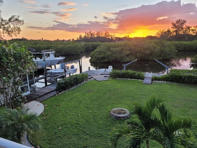yard at dusk with a water view and a boat dock