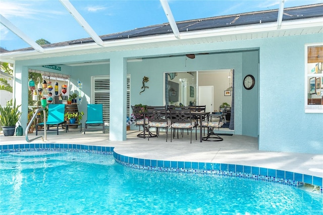 view of swimming pool with glass enclosure and a patio