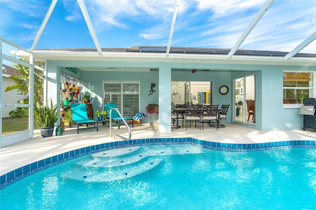 view of swimming pool with a patio area, glass enclosure, and a grill