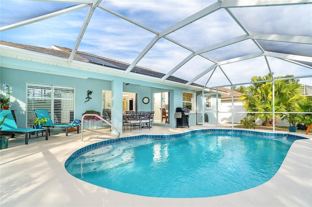 view of swimming pool with a lanai, area for grilling, and a patio area