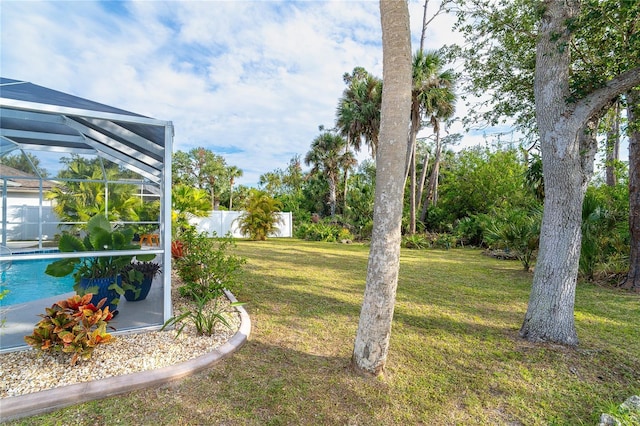 view of yard featuring glass enclosure and a fenced in pool