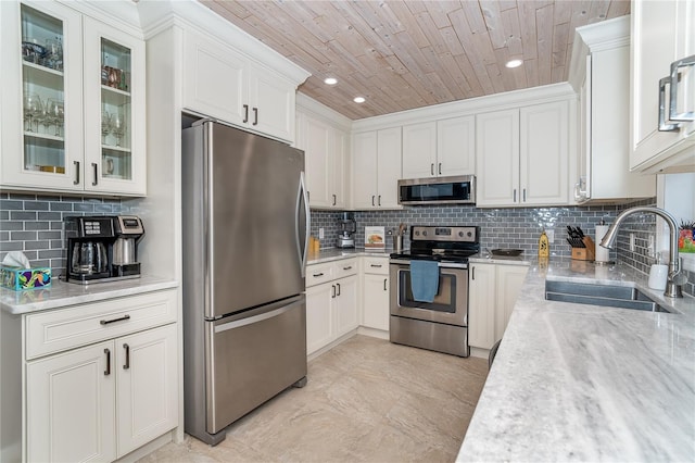 kitchen featuring sink, stainless steel appliances, white cabinetry, and wooden ceiling