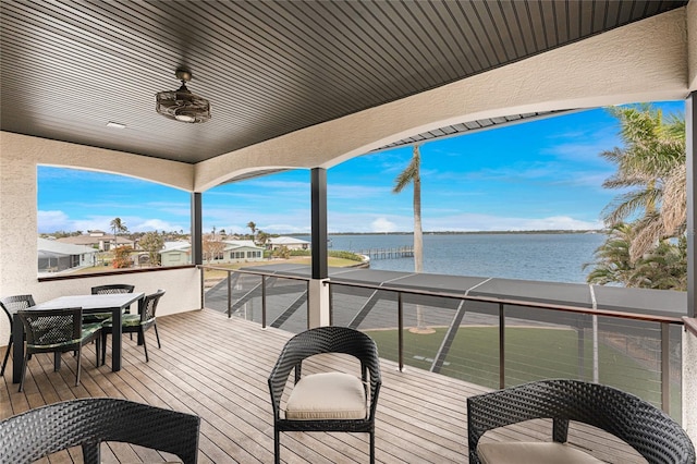 deck with ceiling fan and a water view