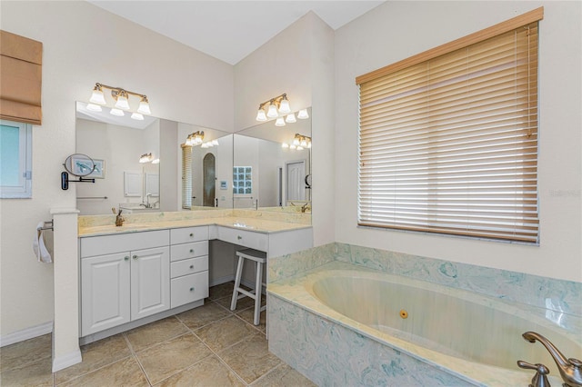 bathroom with tiled bath, vanity, and tile patterned flooring