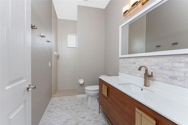 bathroom with decorative backsplash, toilet, vanity, and a tile shower