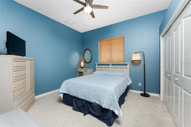 bedroom featuring ceiling fan, light colored carpet, and a closet