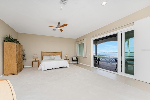 bedroom featuring ceiling fan, access to exterior, and a water view