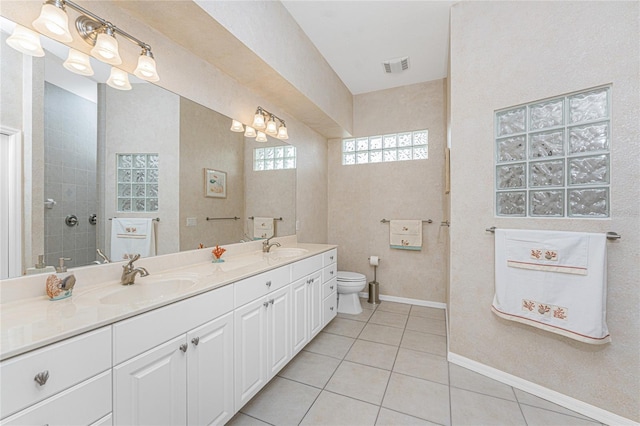 bathroom featuring toilet, tile patterned flooring, a shower, and vanity