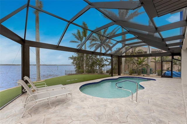 view of pool with glass enclosure, a lawn, a water view, and a patio