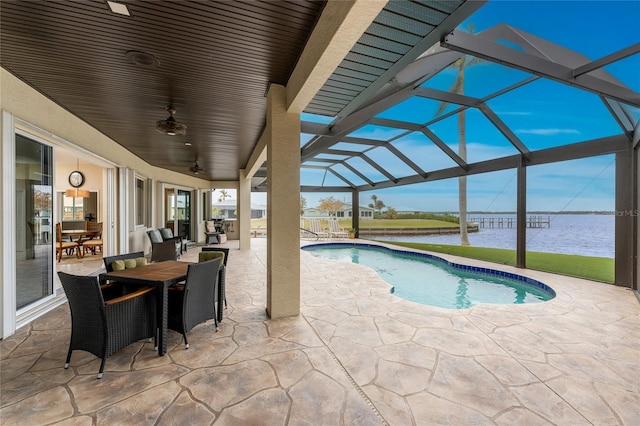 view of swimming pool featuring a patio area, a lanai, ceiling fan, and a water view