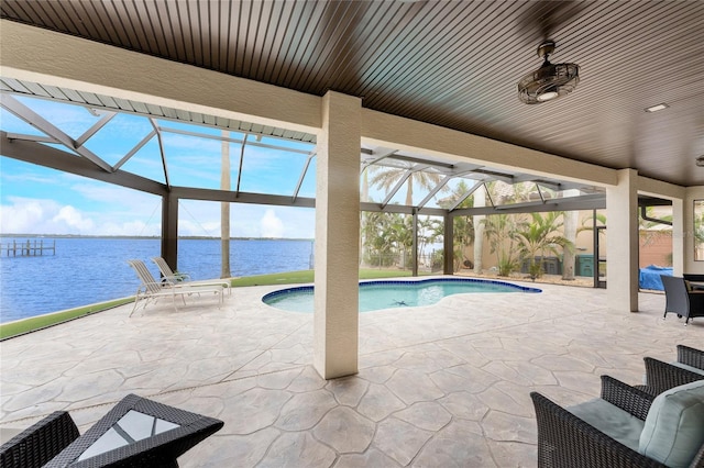 view of pool featuring a water view, a patio, and glass enclosure